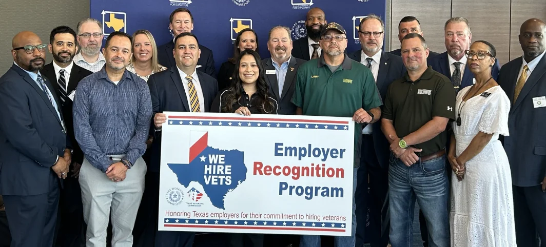 Group of People with sign 'Employer Recognition Program - We Hire Vets. Honoring Texas Employers for Their Commitment to Hiring Veterans'