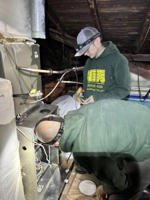 Two Webb's Electric, Heating & Air technicians repairing a furnace in Van Alstyne